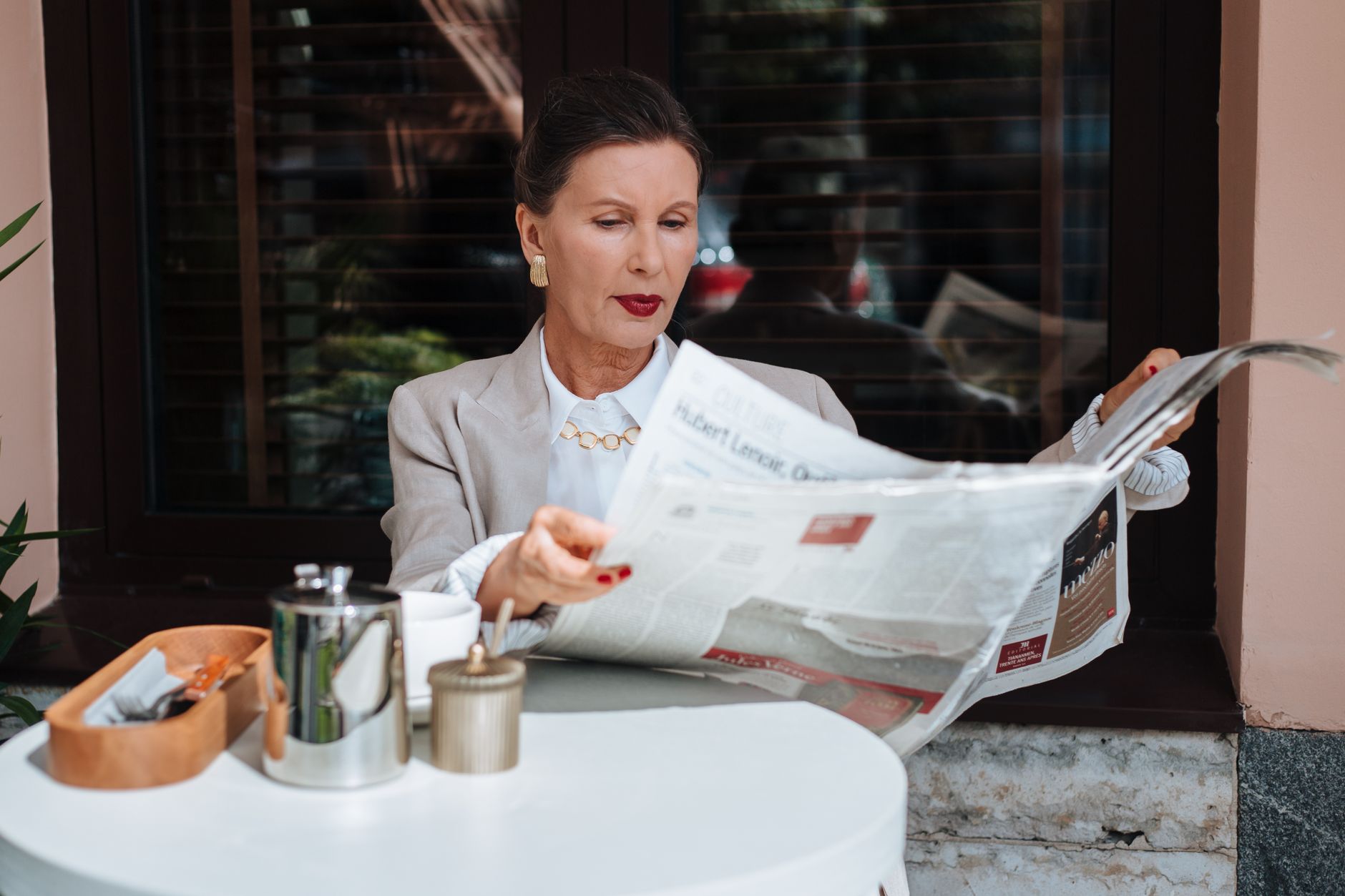 Sophisticated woman enjoying her morning newspaper at a cozy outdoor cafe. — Consolidated Casino: Szybka Gra & Natychmiastowe