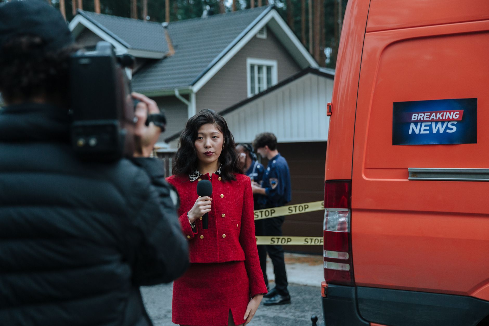 Female reporter in red with microphone reporting live at an outdoor crime scene with a news van. — Der Weg zum Jackpot im Fro